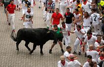 Revellers attempt to dodge a bull during the first running of the bulls at the San Fermin festival in Pamplona, Spain, July 7, 2019.