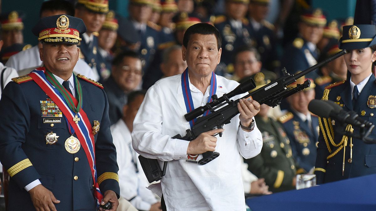 رئيس الفلبين رودريجو دوتيرتي يحمل بندقية قنص خلال حفل بمعسكر في مانيلا - بصورة من أرشيف رويترز