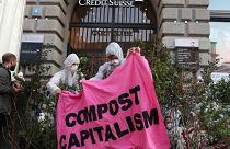 Klimaaktivisten halten ein Banner: "Compost Capitalism"