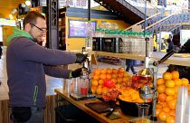 Narancsból, grapefruitból és gránátalmából préselt üdítőitalokat árul egy férfi a Fővám téri Vásárcsarnokban.