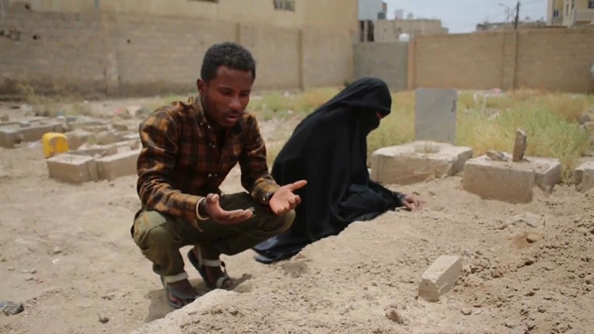 رجل يمني وزوجته يصليان على روح فقيدهما 