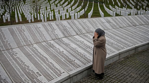 Una mujer reza cerca de la placa conmemorativa con nombres de fallecidos en la masacre de Srebrenica, antes de ver el juicio en el tribunal de La Haya, en Potocari. Una mujer reza cerca de la placa conmemorativa con nombres de fallecidos en la masacre de Srebrenica, antes de ver el juicio en el tribunal de La Haya, en Potocari.