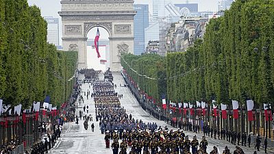 Troops walk down the Champs-Elysees avenue during the Bastille Day parade, Wednesday, July 14, 2021 in Paris. 