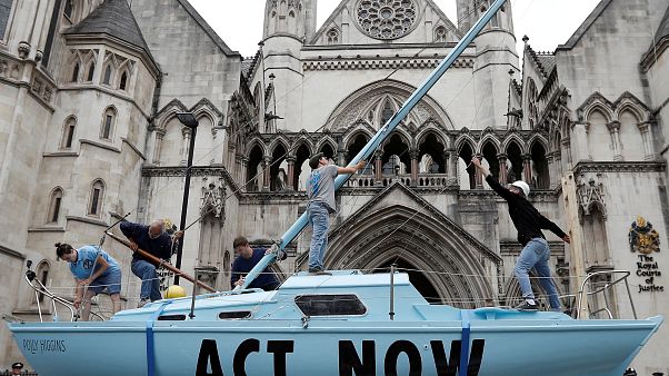 Una singolare forma di protesta: una barca azzurra con scritto "Act Now" davanti alla Corte di Giustizia di Londra. (15.7.2019). Una singolare forma di protesta: una barca azzurra con scritto "Act Now" davanti alla Corte di Giustizia di Londra. (15.7.2019).