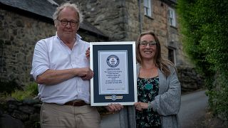Gwyn Headley and Sarah Badham hold a certificate for the record title for world's steepest street, in Harlech, Wales, Britain July 10, 2019.