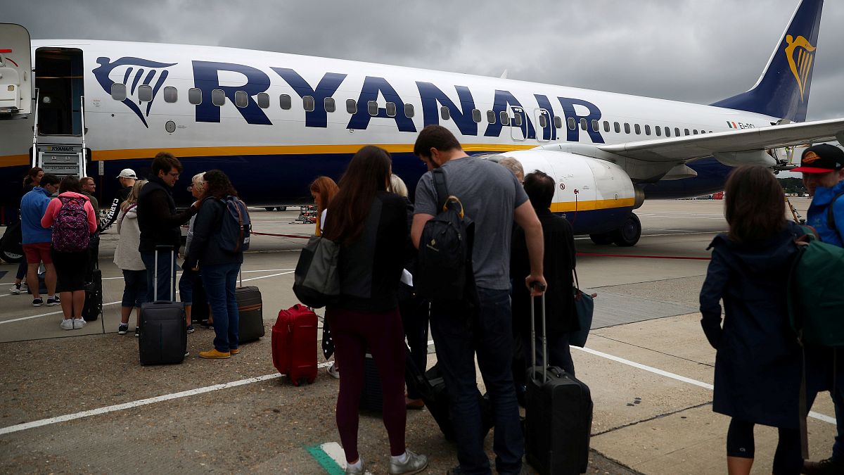 FILE PHOTO: Passengers wait to board a Ryanair flight at Gatwick Airport in London, Britain