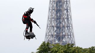 Franky Zapata flies on a Flyboard near the Eiffel Tower during the traditional Bastille Day military parade on the Champs-Elysees Avenue in Paris