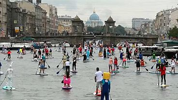 Paddleboard masquerade brings colours to St. Petersburg canals