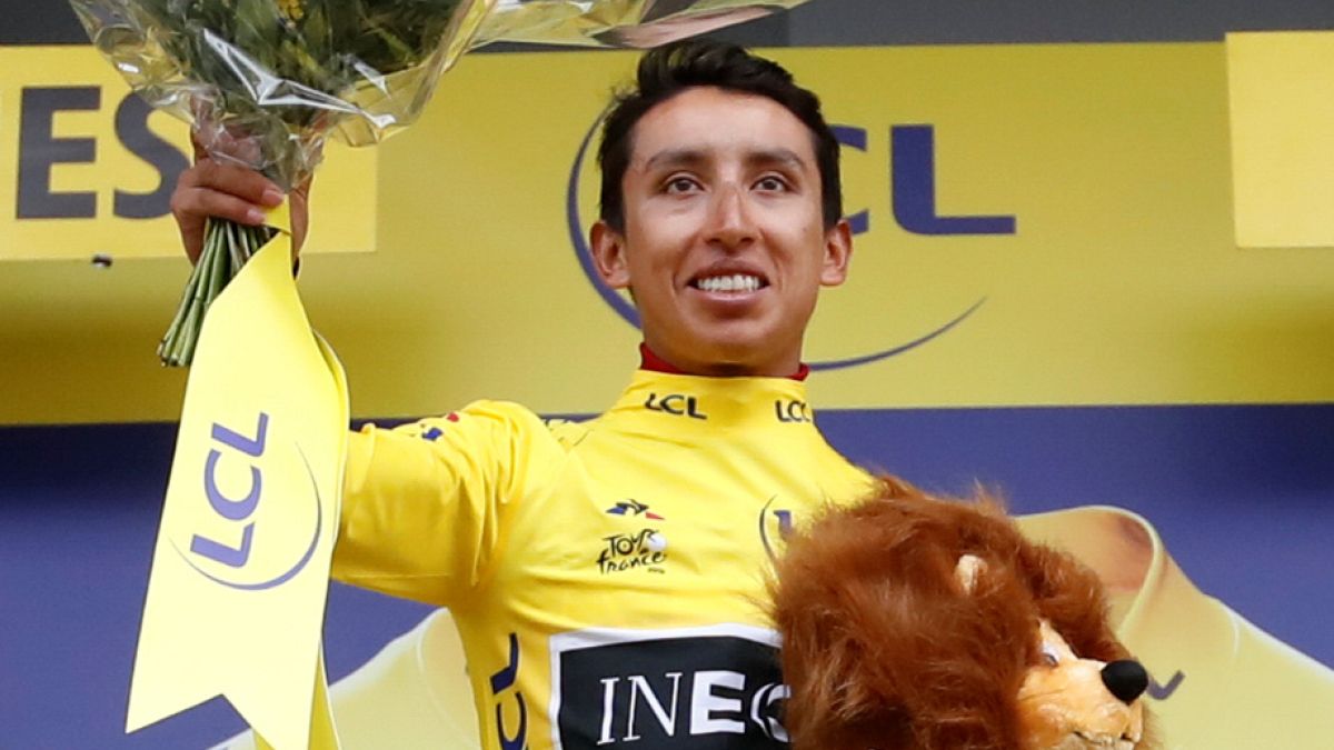 Team INEOS rider Egan Bernal of Colombia celebrates on the podium, wearing the overall leader's yellow jersey on July 26, 2019.