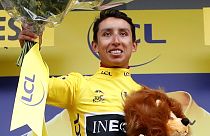 Team INEOS rider Egan Bernal of Colombia celebrates on the podium, wearing the overall leader's yellow jersey on July 26, 2019.