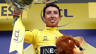 Team INEOS rider Egan Bernal of Colombia celebrates on the podium, wearing the overall leader's yellow jersey on July 26, 2019.