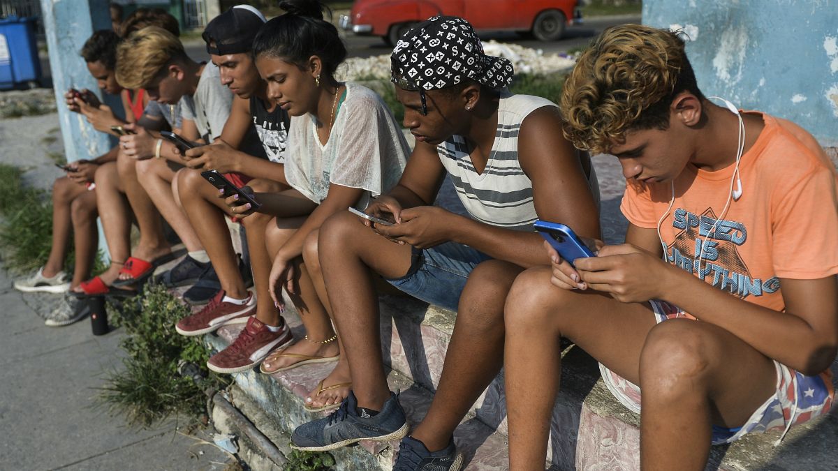 تعدادی از جوانان کوبایی که با گوشی همراه به اینترنت وصل شده اند