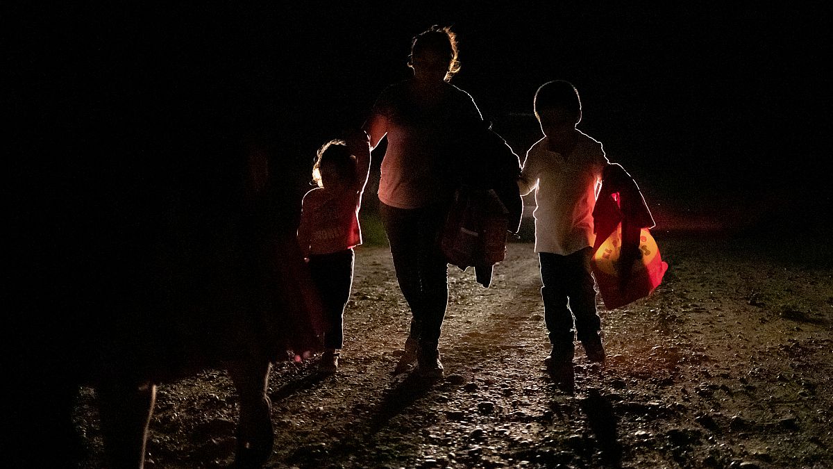 FILE PHOTO: A woman from Honduras and her two children are followed by a US Border Patrol vehicle after illegally crossing into the US from Mexico in Penitas, Texas