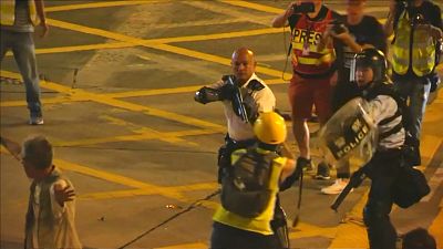 شاهد: أحد ضباط شرطة هونغ كونغ يشهر سلاحه بشكل مباشر على المحتجين