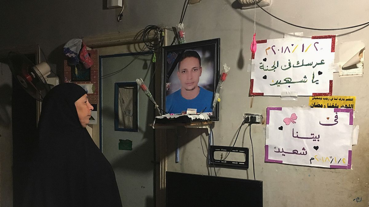 تهاني والدة الشاب لطفي إبراهيم تنظر إلى صورة له معلقة داخل منزل الأسرة في كفر الشيخ يوم 13 يناير كانون الثاني 2019