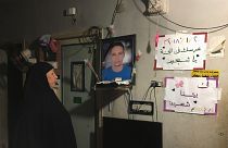 تهاني والدة الشاب لطفي إبراهيم تنظر إلى صورة له معلقة داخل منزل الأسرة في كفر الشيخ يوم 13 يناير كانون الثاني 2019