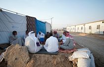 نازحون عراقيون آثروا العودة للمخيمات بعد أن وجدوا الظروف في مخيماتهم صعبة وبيوتهم مهدمة، يجلسون في خيام في شرق الموصل