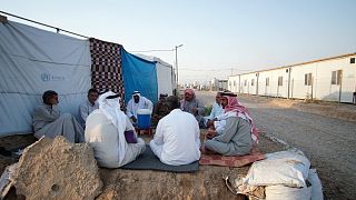 نازحون عراقيون آثروا العودة للمخيمات بعد أن وجدوا الظروف في مخيماتهم صعبة وبيوتهم مهدمة، يجلسون في خيام في شرق الموصل