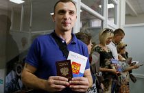 Un residente de la autoproclamada República Popular de Donetsk sostiene su pasaporte ruso y una copia de la Constitución de Rusia
