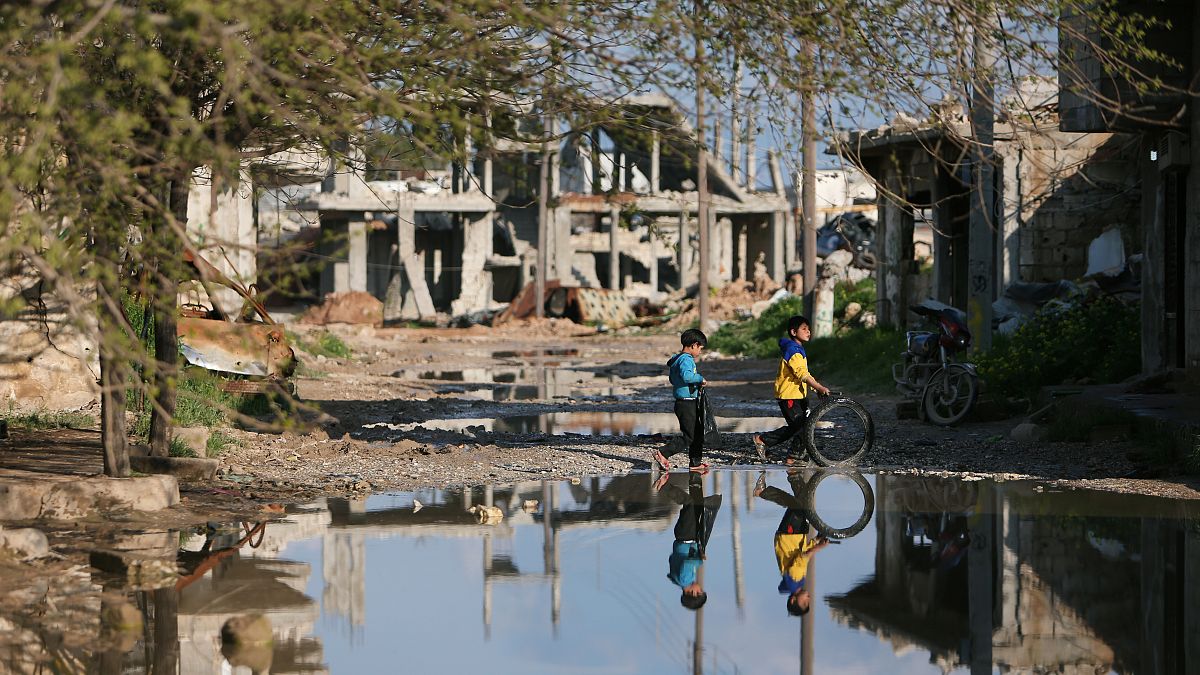 FILE PHOTO: Children play near damaged houses in Kobani, Syria 