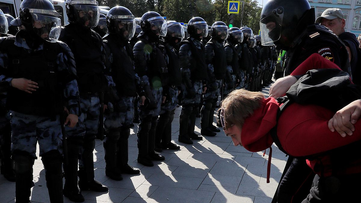 Law enforcement officers detain a participant in a rally calling for opposition candidates to be registered for elections to Moscow City Duma on August 3
