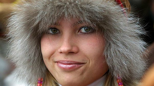 FILE PHOTO: A Saami young woman in national costume smiles during the national festival, Russia June 14, 2003. 