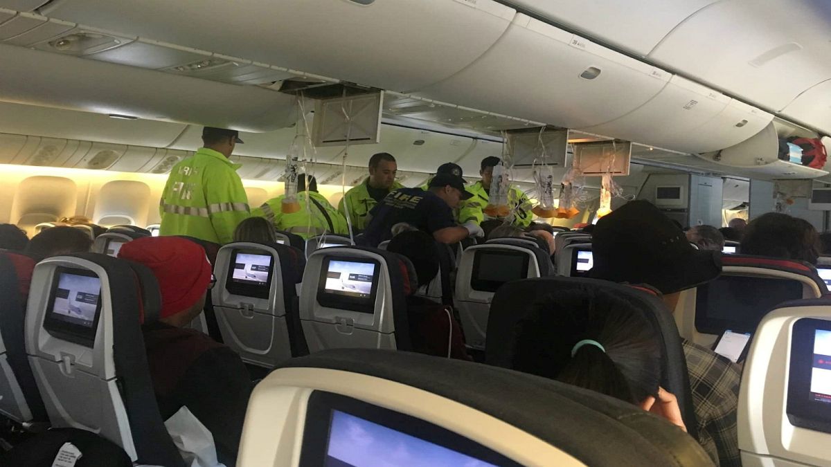 عاملون بخدمات الطوارئ يقدمون يد العون لراكب على متن الطائرة الكندية يوم 11 يوليو تموز 2019
