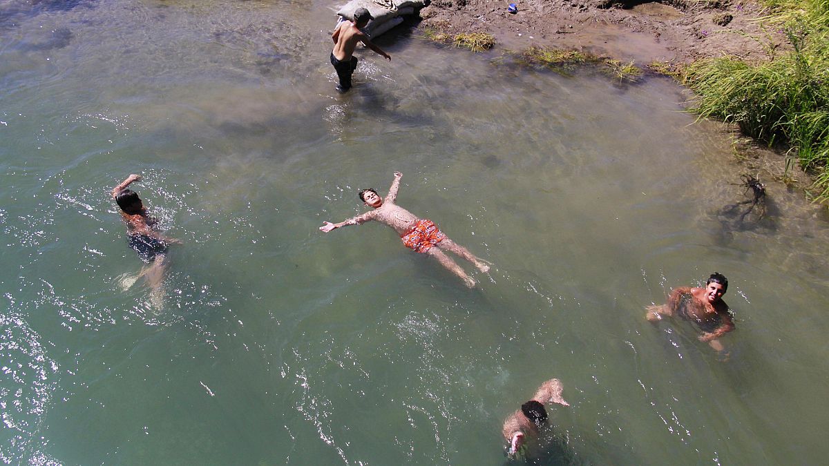 Tunceli'nin Ovacık ilçesinde çocuklar, Kurban Bayramı'nı, Munzur Çayı'nın serin sularında yüzerek geçiriyor. 