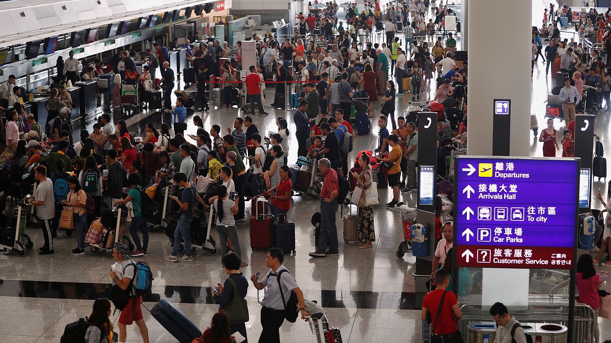 مسافرون يصطفون في مطار هونغ كونغ الدولي الذي أعيد افتتاحه بعد تعطل بسبب الاحتجاجات يوم الثلاثاء