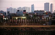 Una partitella di pallone tra ragazzi e, dietro, lo skyline di Giacarta.
