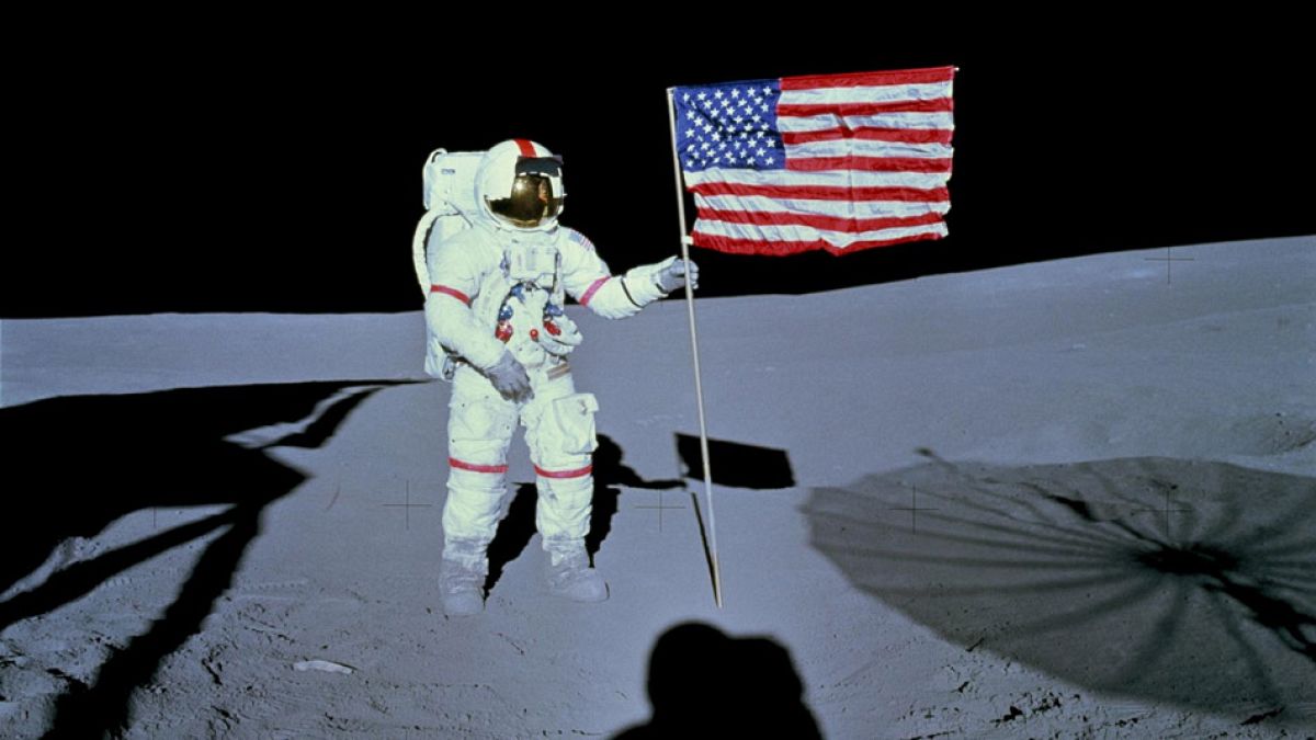 رائد الفضاء آلان  شيبارد، قائد مهمة الهبوط على سطح القمر أبولو 14، إلى جانب علم الولايات المتحدة على سطح القمر