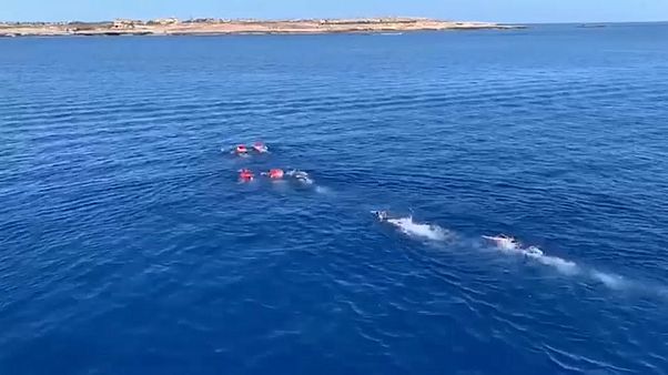 أعضاء طاقم السفينة أثناء إعادتهم للمهاجرين أعضاء طاقم السفينة أثناء إعادتهم للمهاجرين