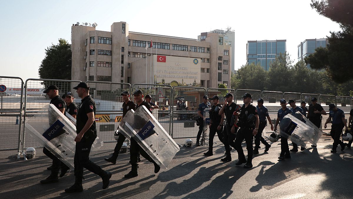 Turkish police walk in front of the Metropolitan Municipality headquarters in Diyarbakir, Turkey, August 19, 2019. 