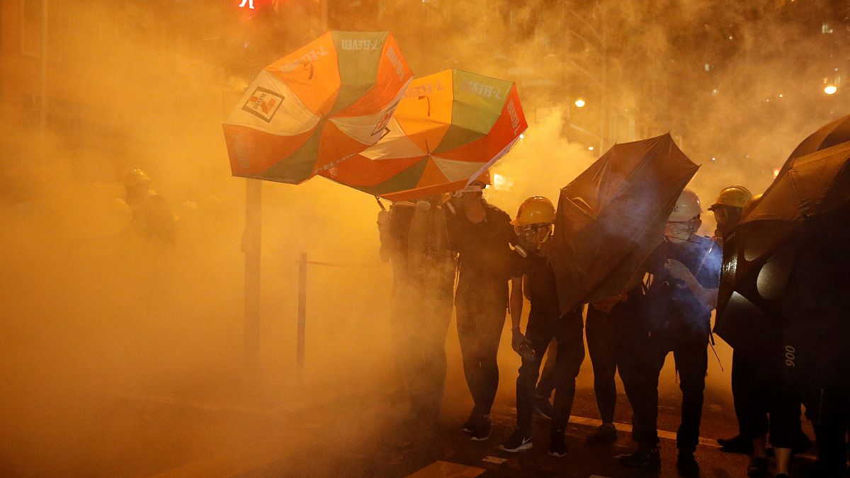 محتجون مؤيدون للديمقراطية يحتمون من الغاز المسيل للدموع بمظلات في هونغ كونغ يوم 28 يوليو تموز 2019 - إدجار سو / رويترز