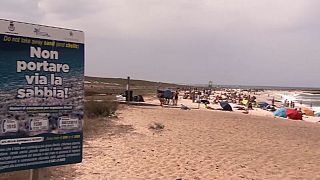 A sign warning people on a beach in Sardinia not to take the sand