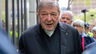 Vatican Treasurer Cardinal George Pell is surrounded by Australian police as he leaves the Melbourne Magistrates Court in Australia, October 6, 2017