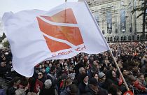 People hold flags with logo of Rustavi 2, Georgia's biggest independent television station, during rally..