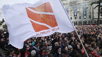People hold flags with logo of Rustavi 2, Georgia's biggest independent television station, during rally..