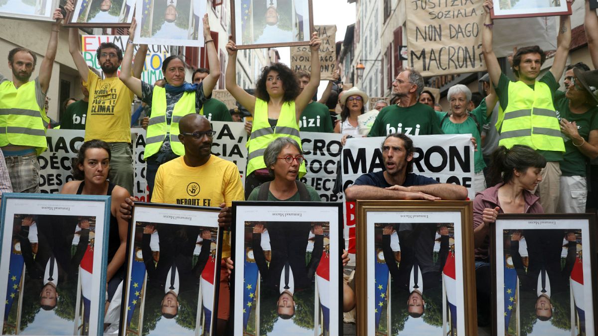 Climate activists rally carrying stolen portraits of Macron near G7