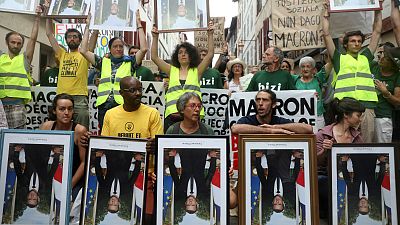 Climate activists rally carrying stolen portraits of Macron near G7
