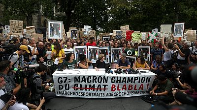 Manifestantes mostram cartaz com a frase: "Macron campeão do 'blá blá blá"