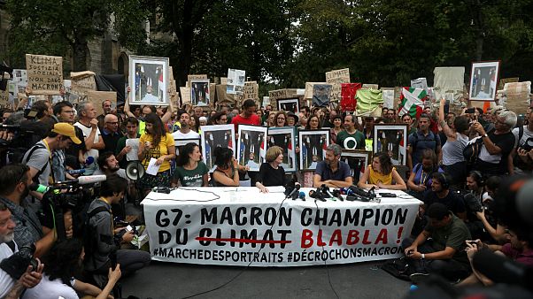 Manifestantes mostram cartaz com a frase: "Macron campeão do 'blá blá blá" Manifestantes mostram cartaz com a frase: "Macron campeão do 'blá blá blá"
