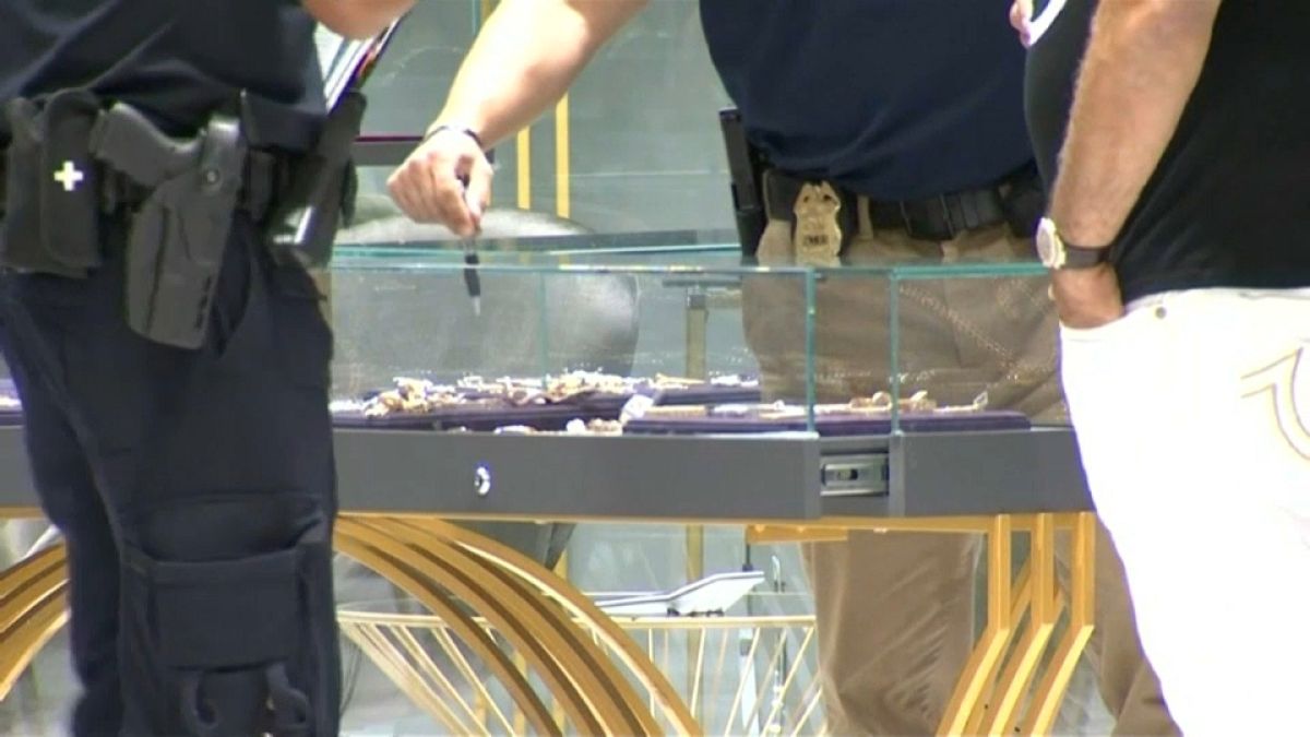 أفراد من الشرطة يعاينون آثار السرقة في محل المجوهرات في نيويورك