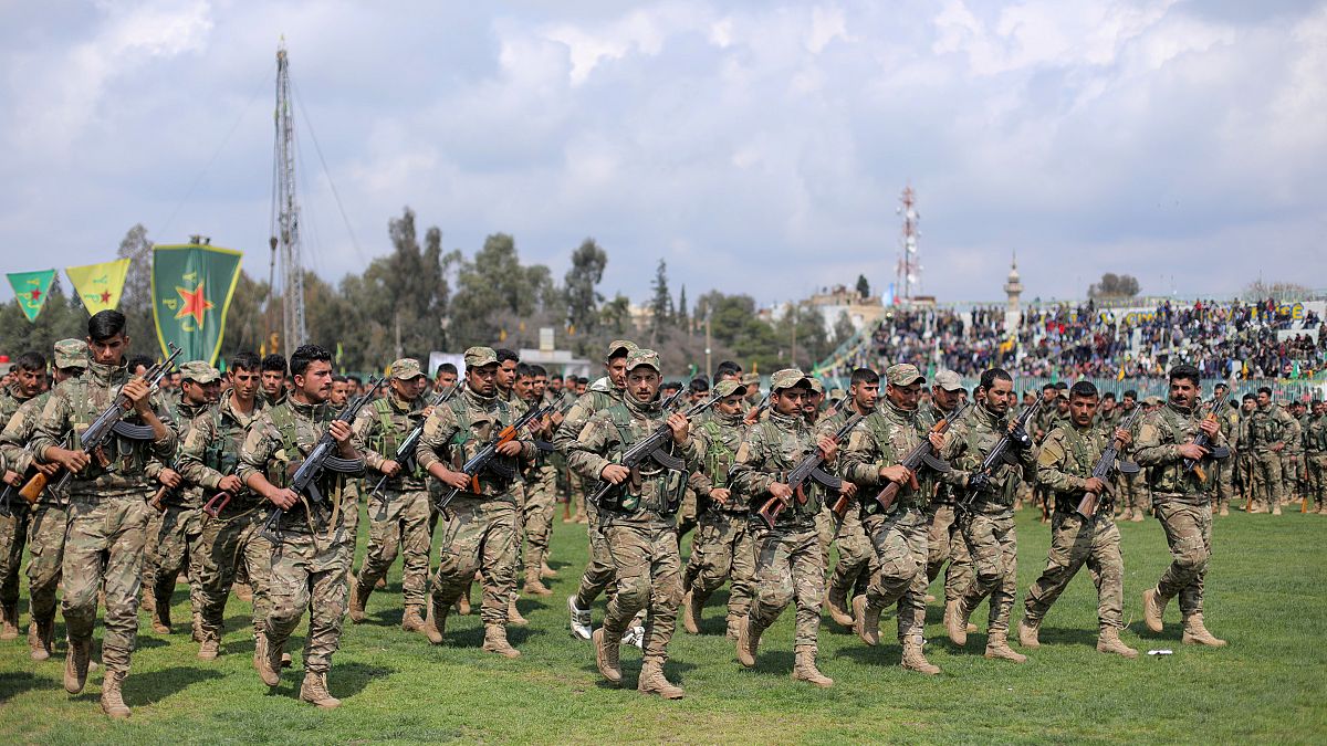 جنود أكراد في وحدات حماية الشعب يشاركون في عرض عسكري احتفالا بالنصر على الدولة الإسلامية، في القامشلي بسوريا