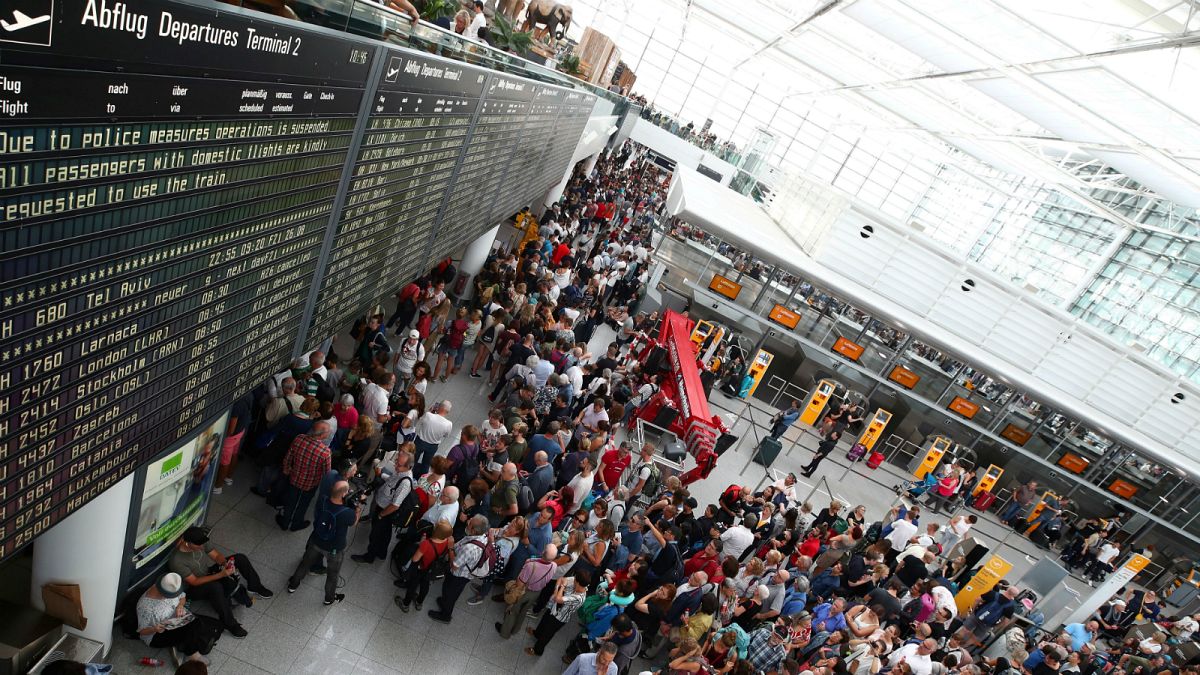 مسافرون ينظرون رحلاتهم في مطار ميونخ- أرشيف رويترز