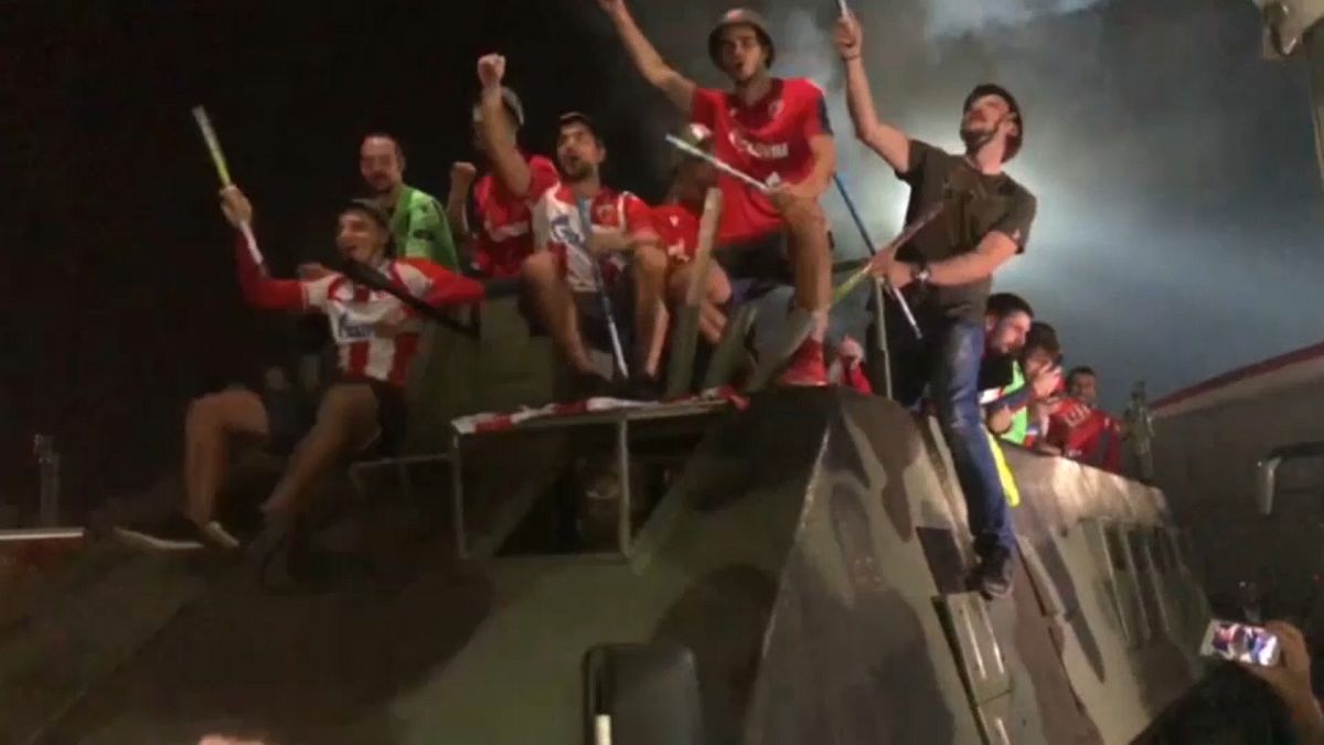 Red Star Belgrade players ride on military vehicle to celebrate win