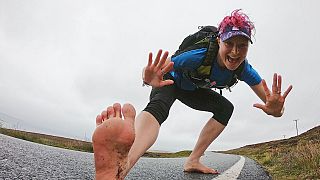 McNuff running across tarmac barefoot at the start of her journey