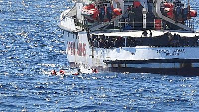 igrants jump off the Spanish rescue ship Open Arms, close to the Italian shore in Lampedusa