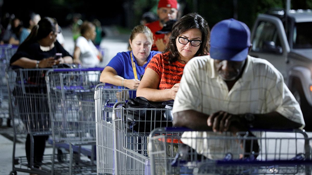 Shoppers wait in line for a Sam's Club store to open before sunrise, as people rushed to buy supplies ahead of the arrival of Hurricane Dorian in Kissimmee, Florida, U.S.