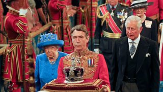 Britain's Queen Elizabeth and Prince Charles walk through the Royal Gallery during the State Opening of Parliament in central London